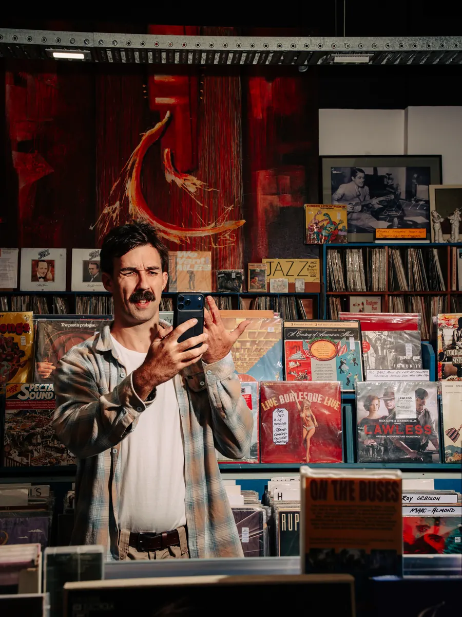 Sev filming on his phone inside a record store